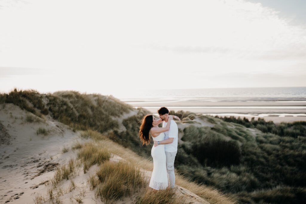 Dramatic portrait of a couple at sunset overlooking the sand dunes
