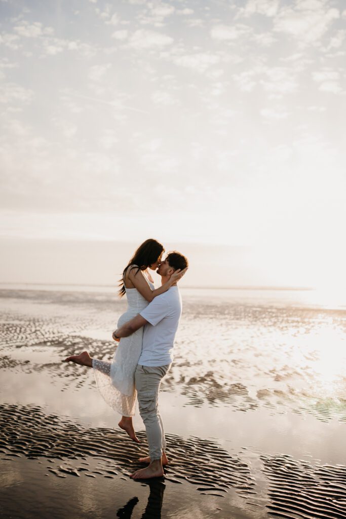 Beautiful portrait of an engaged couple on the beach at sunset
